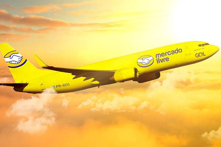 avião amarelo com logotipo do Mercado Livre em voo, em ceu alaranjado