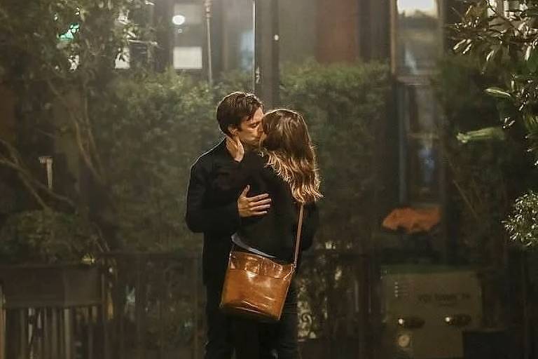 Cena de filme que retrata um homem e uma mulher se beijando no rua