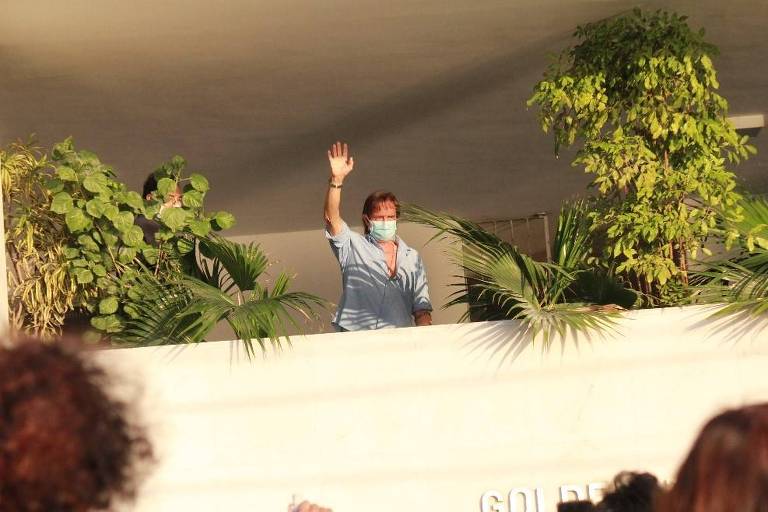 A imagem mostra o cantor Roberto Carlos acenando em uma sacada de prédio