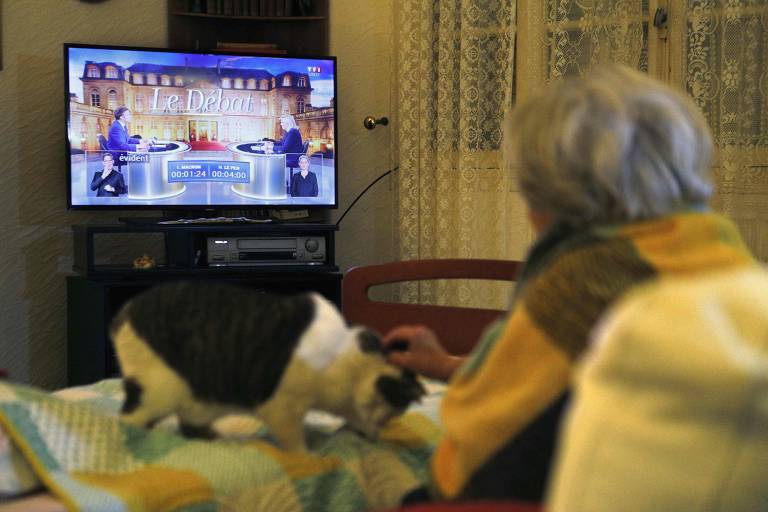 Eleitora assiste a debate entre candidatos a presidente a dias do segundo turno da eleição presidencial na França