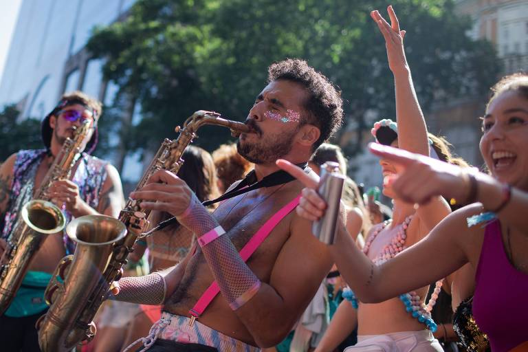 Foliões tocam instrumentos musicais em bloco de rua no Rio