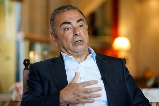 FILE PHOTO: Fugitive former car executive Carlos Ghosn, gestures as he talks during an interview with Reuters in Beirut