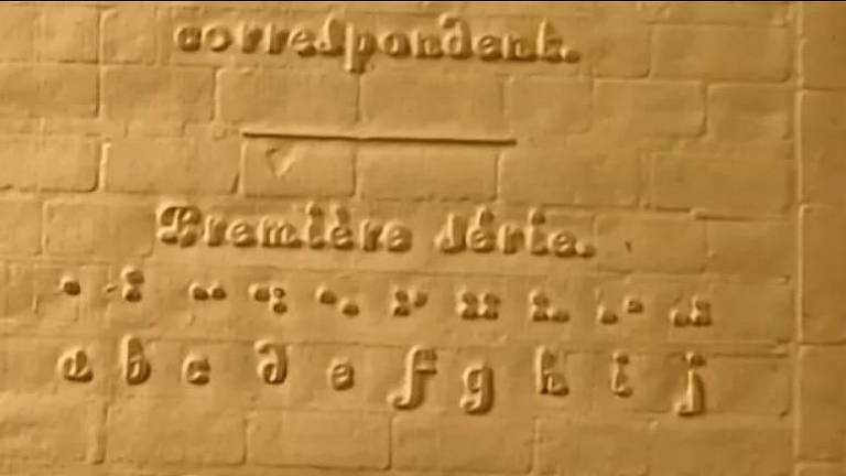 Tábua com inscrição em  alto relevo e em braille