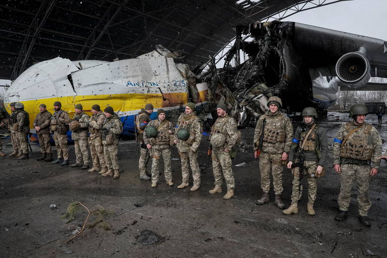 Soldados ucranianos em frente ao avião no aeroporto de Hostomel