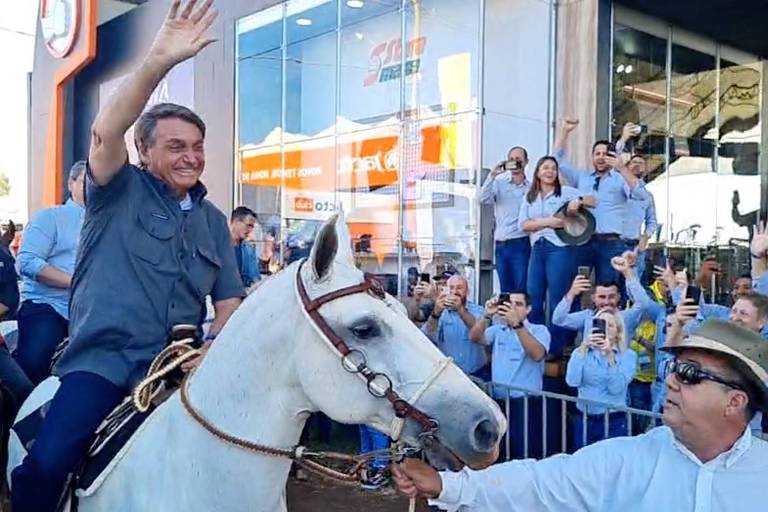 O presidente Jair Bolsonaro acena para apoiadores durante passeio de cavalo na cidade de Ribeirão Preto, no interior de São Paulo