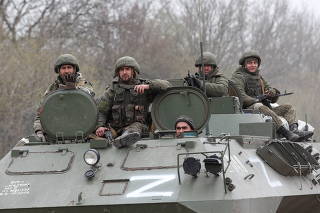 Service members of pro-Russian troops drive an armoured vehicle near Mariupol