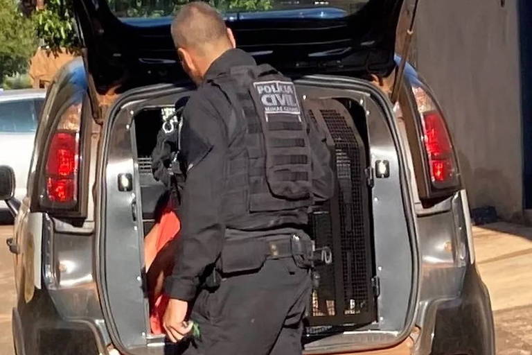 policial de farda preta escrito policia civil de costas com carro com porta mala aberto