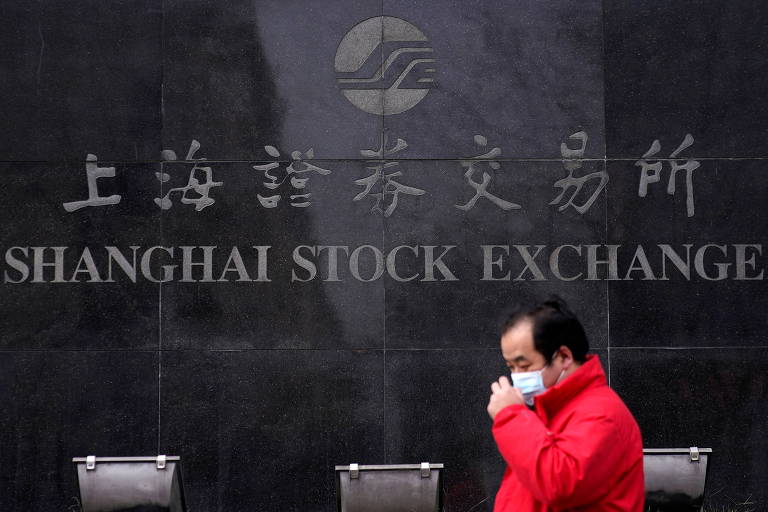 Pedestre diante da Bolsa de Valores de Xangai, na China