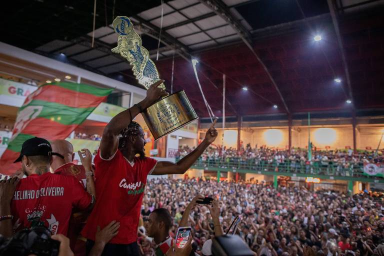 Diretores e ator que interpretou exu da escola de samba Grande Rio, mostram troféu de campeão do Carnaval carioca na quadra da escola em Duque de Caxias