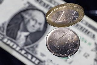 FILE PHOTO: Coins of one Russian rouble and one Euro are seen next to a U.S. one dollar banknote in this picture illustration