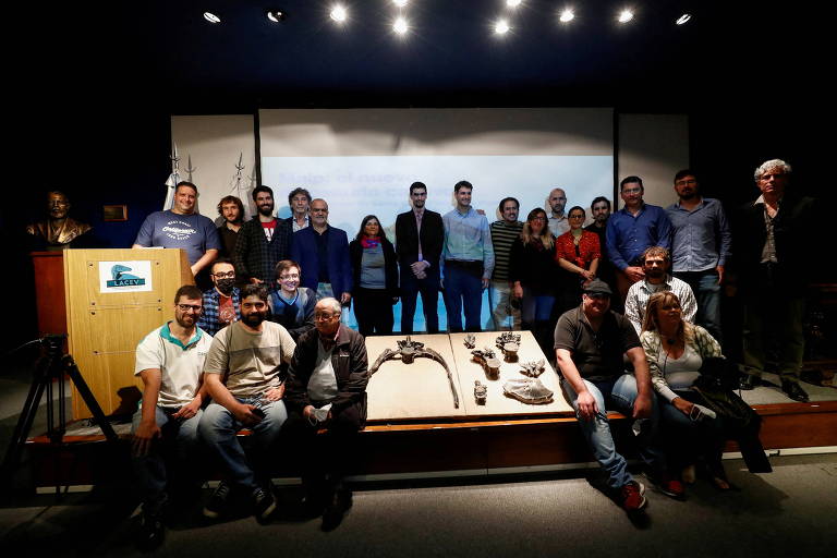 O paleontologista argentino Mauro Aranciaga Rolando posa para foto com os membros de sua equipe no Museu de História Natural de Buenos Airese os ossos fossilizados do megarraptor
