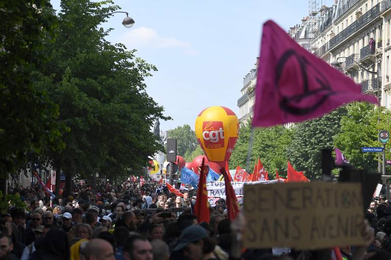 Manifestantes agitam bandeiras de sindicatos e carregam cartazes na manifestação devido ao Dia do Trabalho, na Praça da República, em Paris