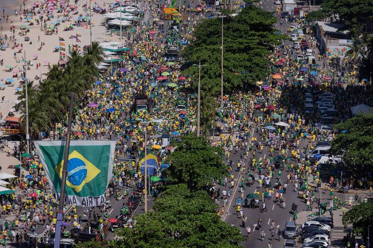 Imagem aérea mostra centenas de pessoas, muitas vestindo amarelo, na orla de Copabana, na zona sul do Rio de Janeiro. No local há bandeiras do Brasil