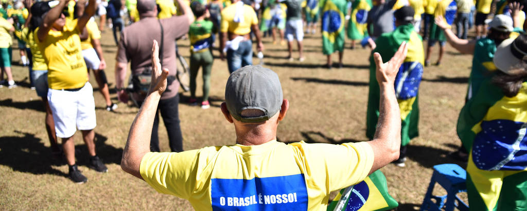 Manifestante se ajoelha pra rezar em ato bolsonarista em Brasília