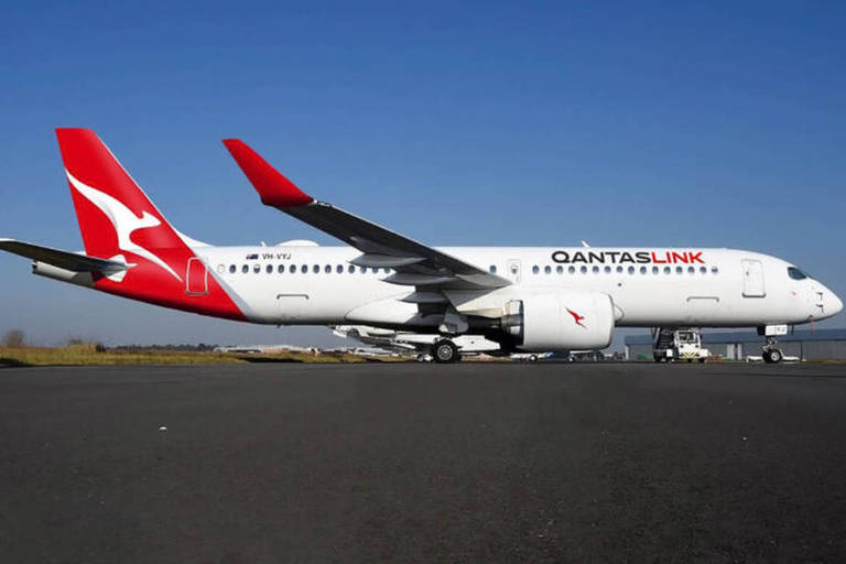 avião branco com cauda vermelha em solo