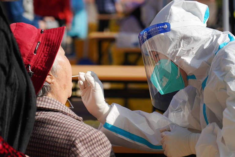 Profissional de saúde faz teste rápido para Sars-CoV-2 em uma idosa residente do distrito de Shijingshan, em Pequim