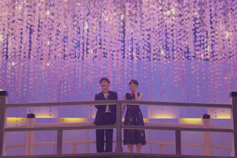 Casal em cima de uma ponte com rosas em cena de Casamento às Cegas Japão