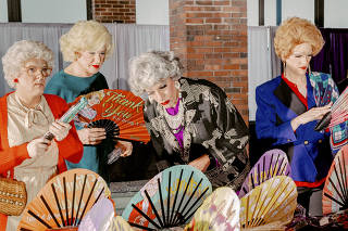 Members of the Hell in a Handbag drag troupe shop for fans at the GoldenCon fan convention, which featured a vendors market for sundry items like ?Golden Girls? fans, in Chicago, April 22, 2022. (Evan Jenkins/The New York Times)