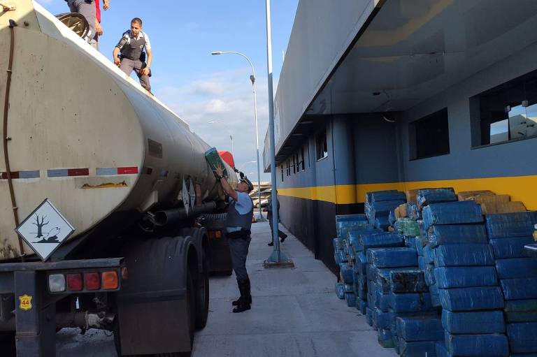 Policiais militares rodoviários tiram maconha do tanque de caminhão para transporte de combustível; apreensão de 5,4 toneladas da droga, em Piratininga (SP), na quinta-feira (SP) é a maior do ano 