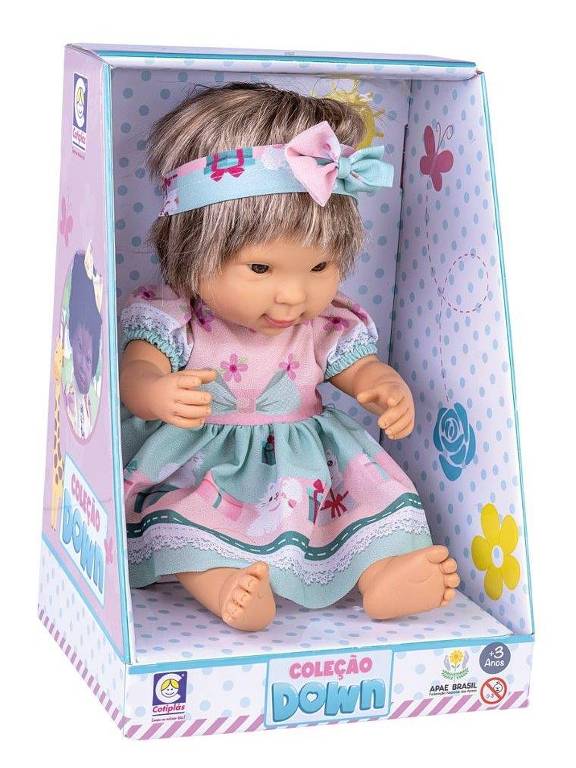 boneca com síndrome de Down de cabelo loiro e roupa azul e rosa