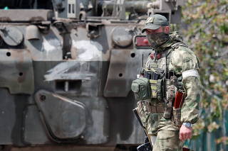 A service member of pro-Russian troops stands guard near a temporary accommodation centre in Bezimenne