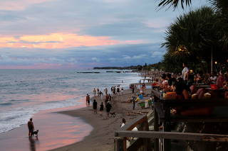 FILE PHOTO: Tourists enjoy the sunset at Canggu beach amidst the COVID-19 pandemic in Bali