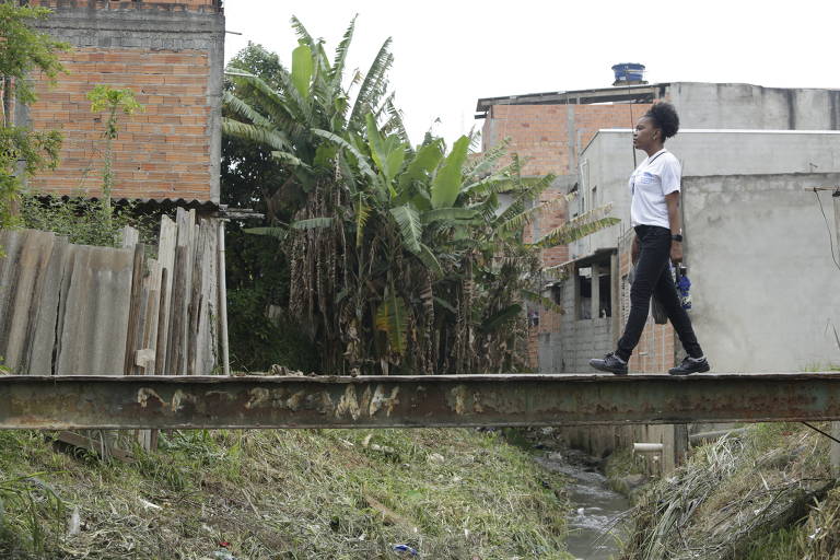 A agente comunitária de saúde Catarina de Jesus caminha por passarela em comunidade de Cidade Tiradentes, São Paulo, em setembro de 2021