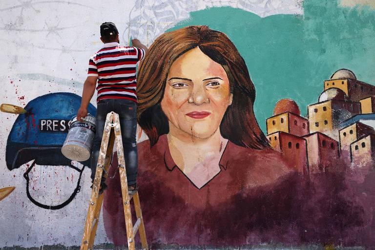 Artista pinta mural em homenagem à jornalista Shireen Sbu Akleh, em Gaza