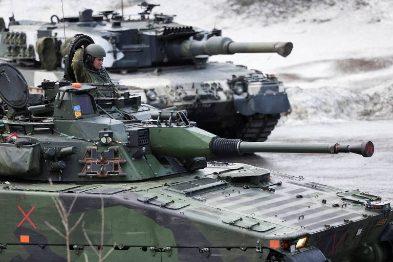 Um blindado de combate Stridsfordon-90 sueco (primeiro plano) e um tanque Leopard-2 finlandês durante exercício conjunto com a Otan na Noruega, em março deste ano