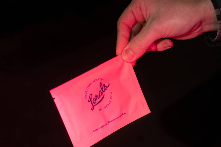 Imagem em close mostra a mão de uma pessoa segurando uma embalagem no formato quadrado escrito: Lorals