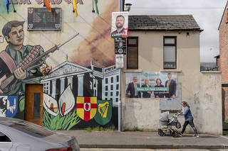 A mural in favor of a united Ireland alongside election posters on the Falls Road, a Catholic stronghold in Belfast, Northern Ireland, on April 28, 2022.  (Andrew Testa/The New York Times)