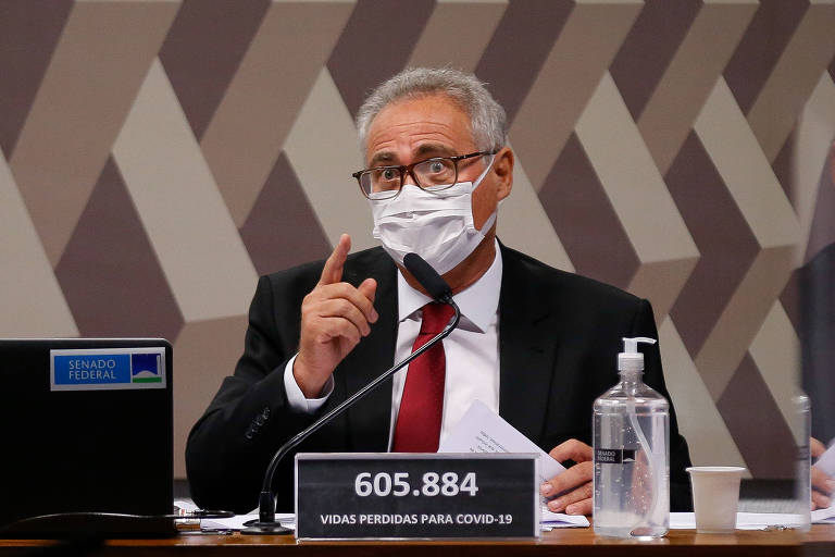 Foto mostra o senador Renan Calheiros (MDB-AL) durante sessão da CPI da Covid. Ele é um homem branco, que veste uma máscara. Veste um terno cinza, com camisa clara