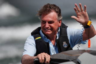 Brazil's President Bolsonaro rides a jet ski during a boat ride with supporters, in Brasilia