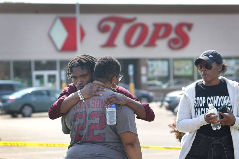 Pessoas se abraçam em frente ao supermercado no qual um homem matou dez pessoas a tiros em Buffalo, nos EUA