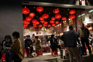 Customers wait in front of a restaurant in Beijing