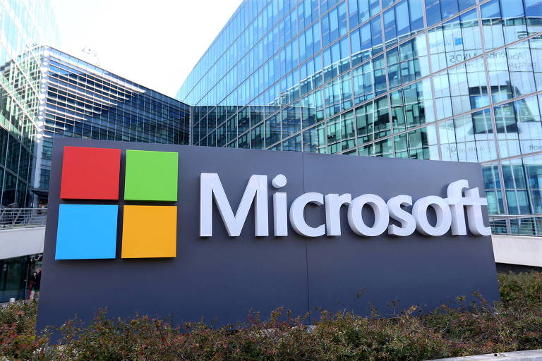A palavra Microsoft aparece escrita, em letras brancas, ao lado da logomarca da companhia, na frente da sede da empresa em Issy-les-Moulineaux, na França