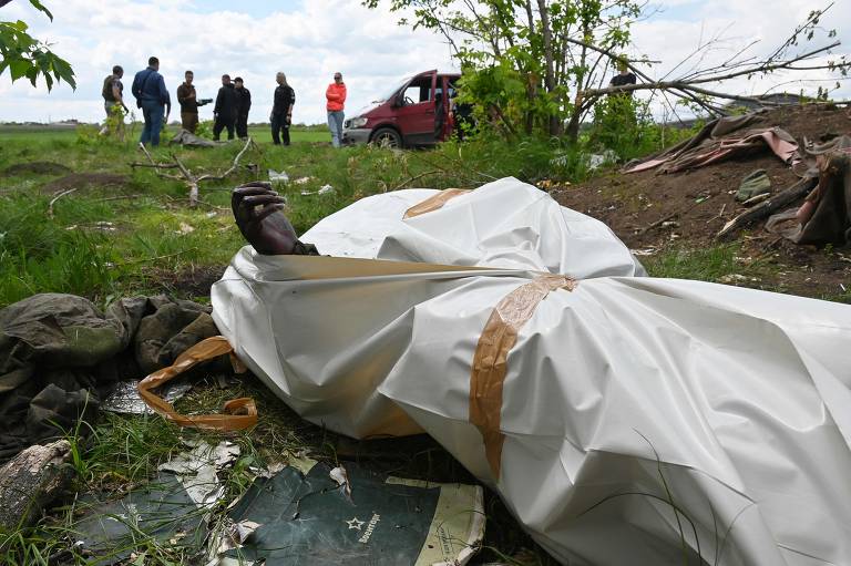 Foto mostra um saco para corpos enquanto equipe forense da polícia ucraniana realiza a exumação de corpos que diz ser DE soldados russos, fora da vila de Mala Rogan, perto de Kharkiv