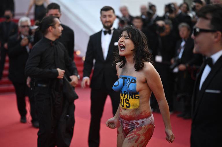 Mulher fica nua no tapete vermelho do Festival de Cannes, pinta bandeira da Ucrânia no corpo com a frase 'parem de nos estuprar' e é afastada por seguranças