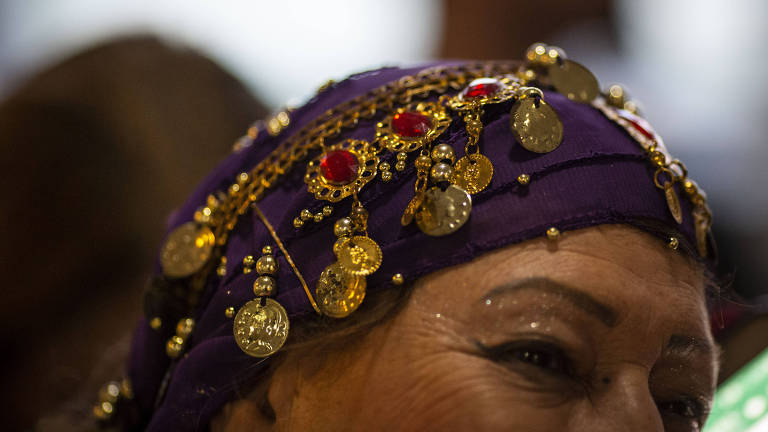 Cigana usa lenço e medalhas na cabeça