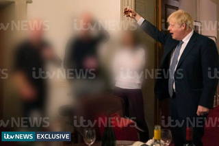 A handout picture shows British Prime Minister Boris Johnson raising a glass during a party at Downing Street, amid the coronavirus disease (COVID-19) pandemic in London