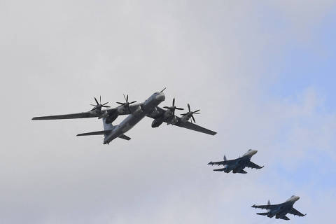Russian Tupolev TU-95 and Sukhoi Su-35s fighter jets fly over Red Square in Moscow during a rehearsal for the WWII Victory Parade on May 4, 2022. - Russia will celebrate the 77th anniversary of the 1945 victory over Nazi Germany on May 9. (Photo by Natalia KOLESNIKOVA / AFP)