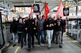 Former employees and union members protest inside the Chinese CAOA Chery factory against the closure which has fired more than 400 workers in Jacarei
