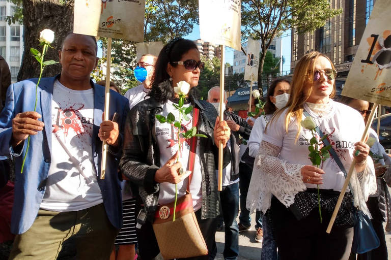 Pessoas protestam com placas e flores na porta do Tribunal do Júri da Justiça Federal em Belo Horizonte