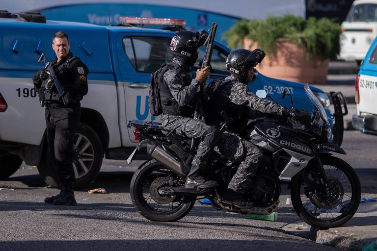 Dois policiais em uma moto e outro a pé fazem segurança na frente do Hospital Getúlio Vargas, no Rio de Janeiro