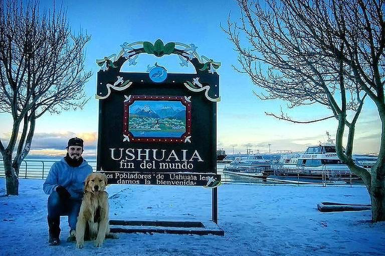  Jesse e Shurastey posam ao lado de placa em Ushuaia