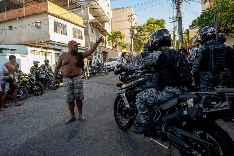 Morador grita com policiais militares em frente ao hospital Getúlio Vargas, após a operação na Vila Cruzeiro