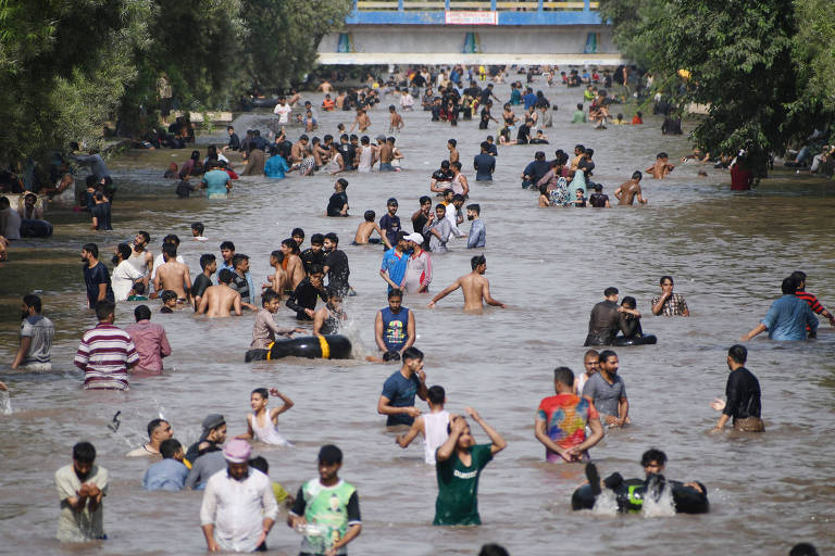 Pessoas se refrescam em um canal em Lahore, no Paquistão, outro país castigado pela forte onda de calor