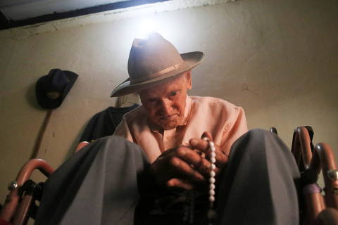 Venezuelan Juan Vicente Mora, declared the oldest person in the world by Guinness World Records, holds beads in his hands inside his home as he celebrates his 113th birthday on Friday, in San Jose de Bolivar, Tachira state, Venezuela May 24, 2022. Picture taken May 24, 2022.  REUTERS/Carlos Eduardo Ramirez ORG XMIT: GGGHNR02