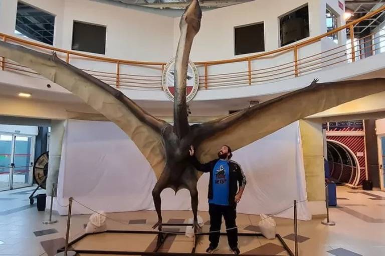 O paleontólogo Leonardo Ortiz ao lado de uma réplica em tamanho real da espécie recém-descoberta