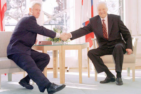 Reunião entre E.U.A e Rússia: President Bill Clinton and Russian President Boris Ieltsin [R]  reach out across the table to gree one another before starting talks on NATO expansion at the Helsinki summit, March 21. The meeting  took place at the Finnish Presidential residence of Mantyniemi.  mal/TASS/Photo by Alexander Chumichev  REUTERS*** NÃO UTILIZAR SEM ANTES CHECAR CRÉDITO E LEGENDA***